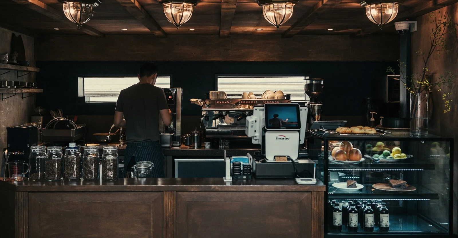 A café counter with warm wood and pastries